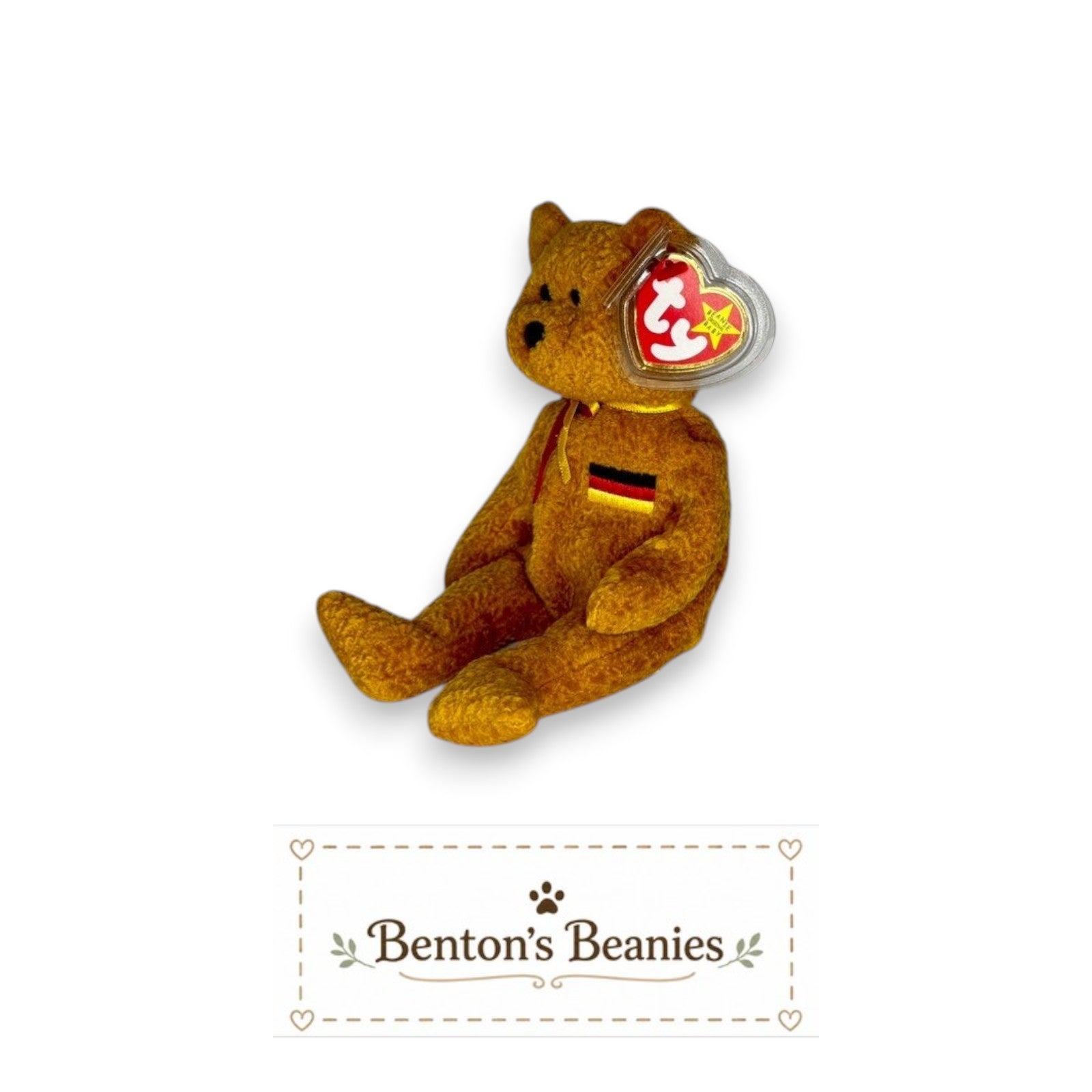 Benton's Beanies Germania the Bear Ty Beanie Baby with golden-brown plush, red ribbon, and German flag chest patch.
